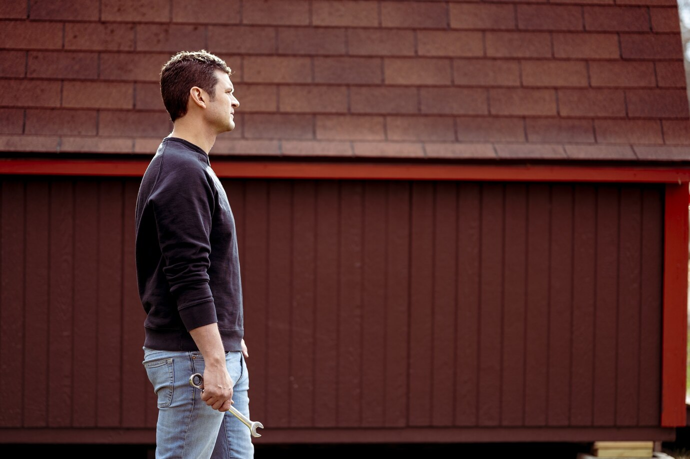 Man with a wrench on the background of a garage door